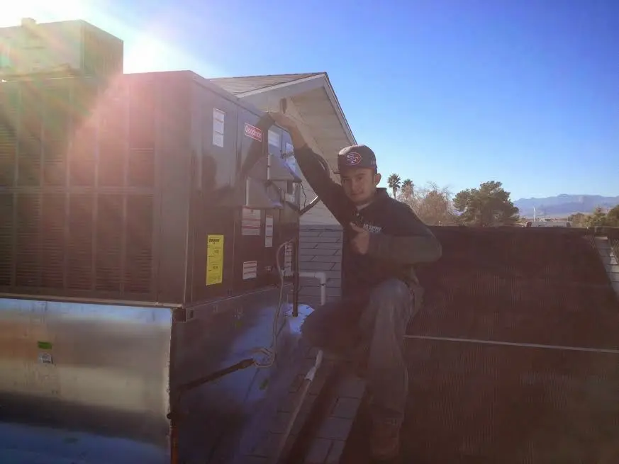 HVAC technician performing Air Duct Repair on a rooftop unit in Rockville Centre